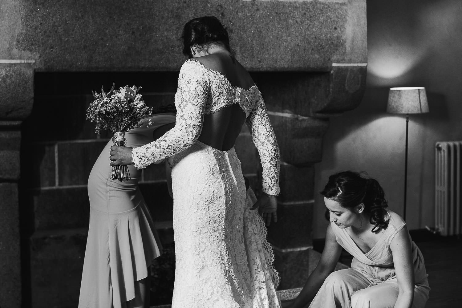 Hermana ayuda a la novia a vestirse