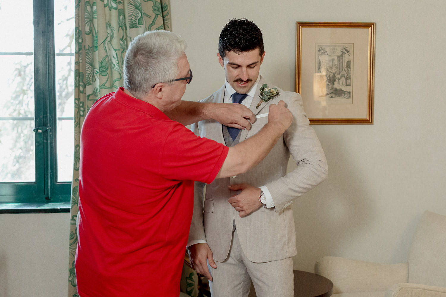 Una boda civil en el Parador de Jarandilla 4 El novio mantiene una postura erguida y confiada mientras recibe ayuda con los detalles finales de su look, listo para dar el siguiente paso en su boda