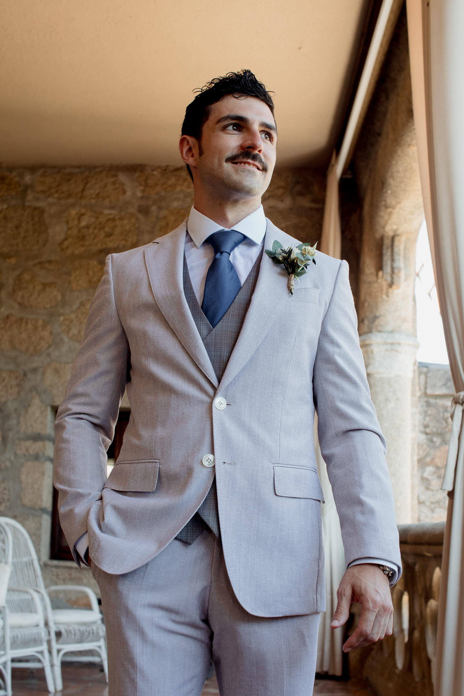 Una boda civil en el Parador de Jarandilla 7 Una foto de la parte baja del torso del novio, destacando su chaleco perfectamente abrochado y el pantalón claro a juego, reflejando la armonía de su estilo.