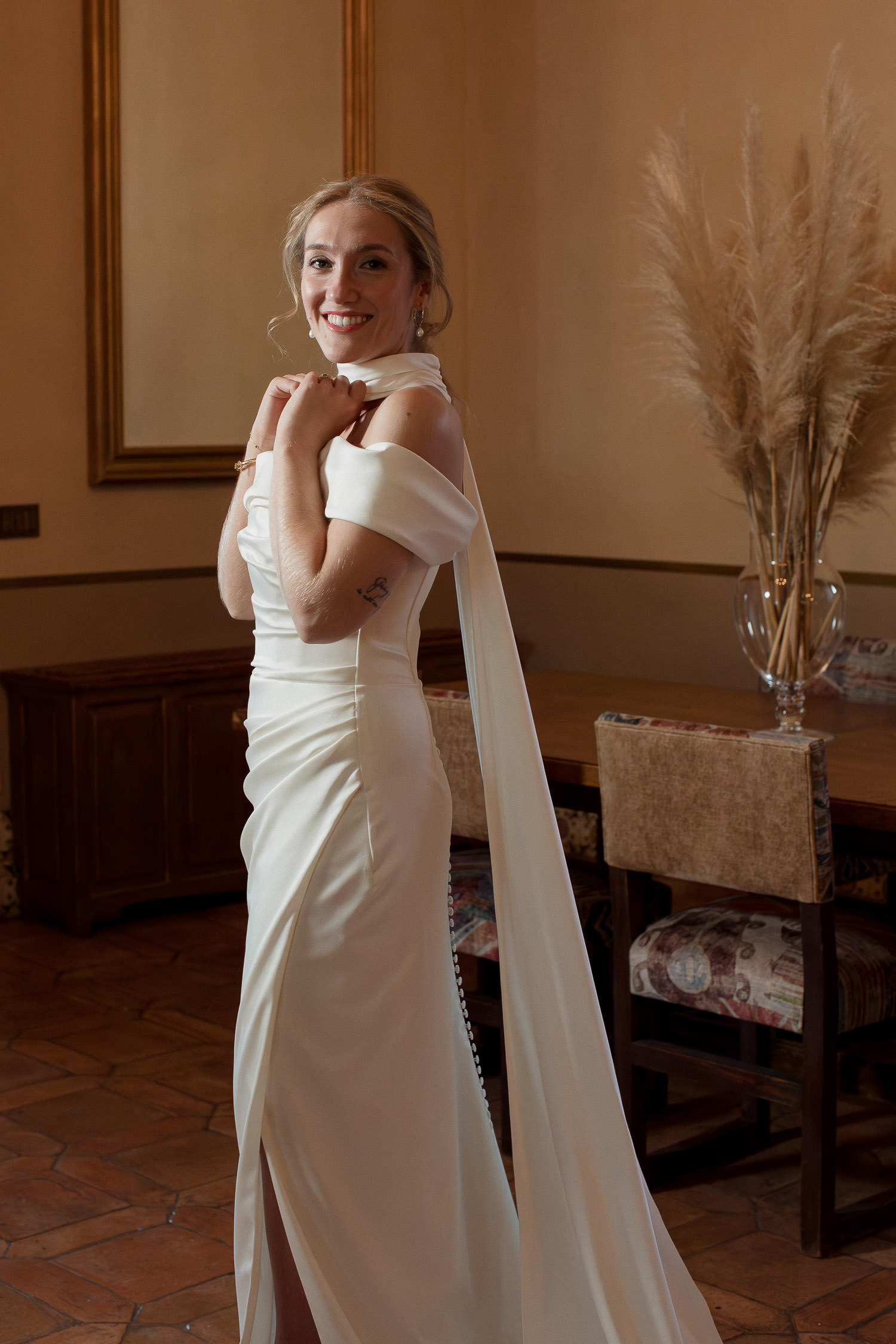 Una boda civil en el Parador de Jarandilla 22 La novia posa con su vestido de novia de hombros descubiertos y cola larga en un salón histórico, lista para la boda civil en el Parador de Jarandilla de la Vera, en un entorno elegante y atemporal.